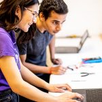 Two people working at a computer.