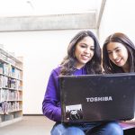 Two students looking at a laptop.