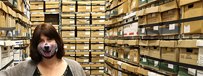 Woman in room surrounded by boxes and boxes of papers.