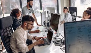 Several programmers looking at computer code.