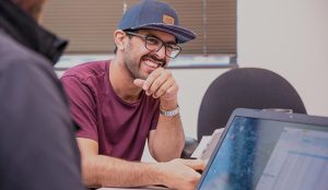 UW student working with another student with a laptop.