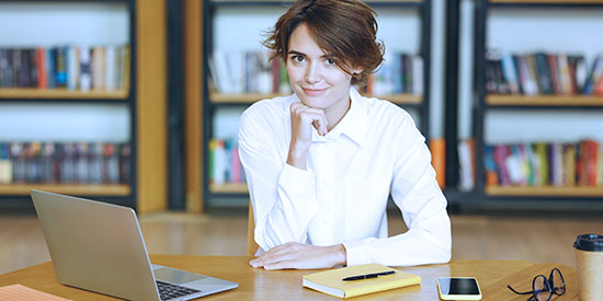 A woman at a desk with a laptop.
